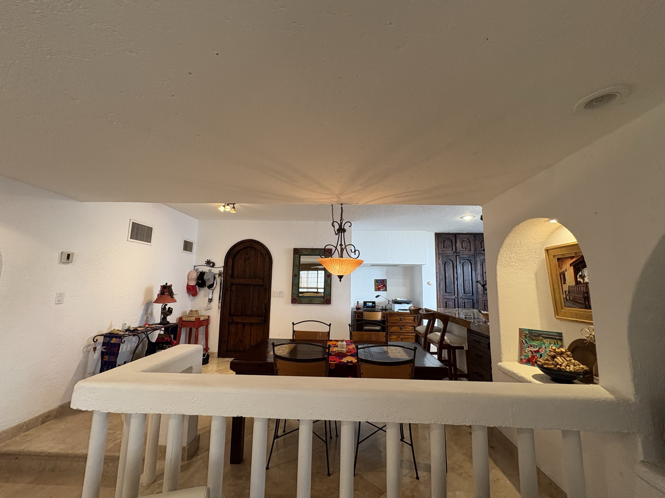 Living and kitchen area with arched details and chandelier