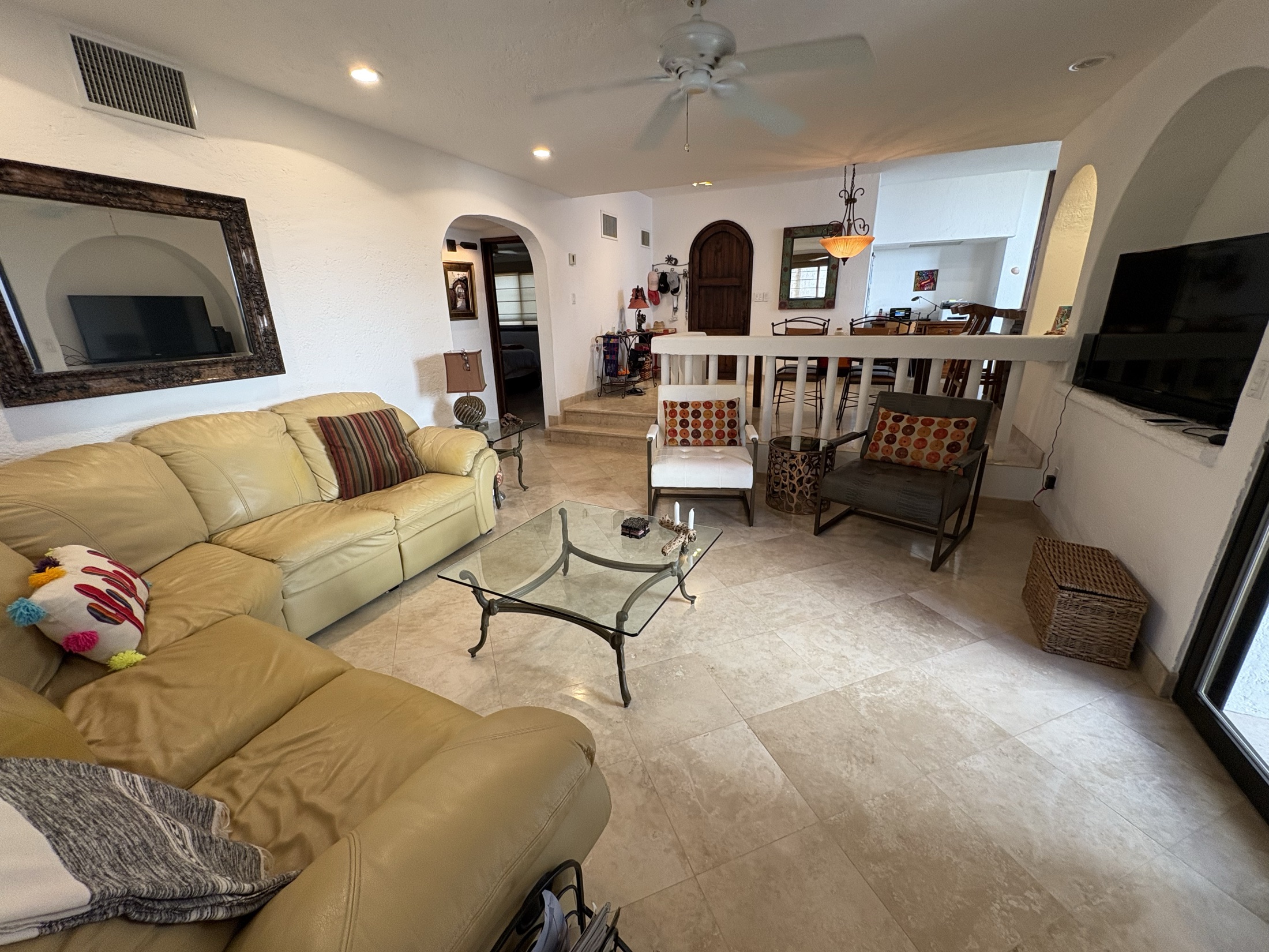 Living room with sofa, dining area, and entry stairs
