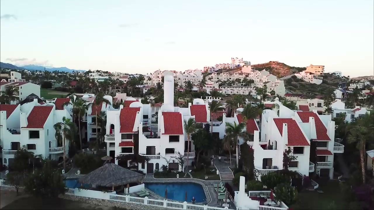 Aerial view of Villas Baja with pool, red tile roofs, and hillside homes
