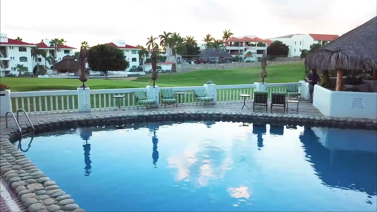 Pool with reflected sky and golf course beyond